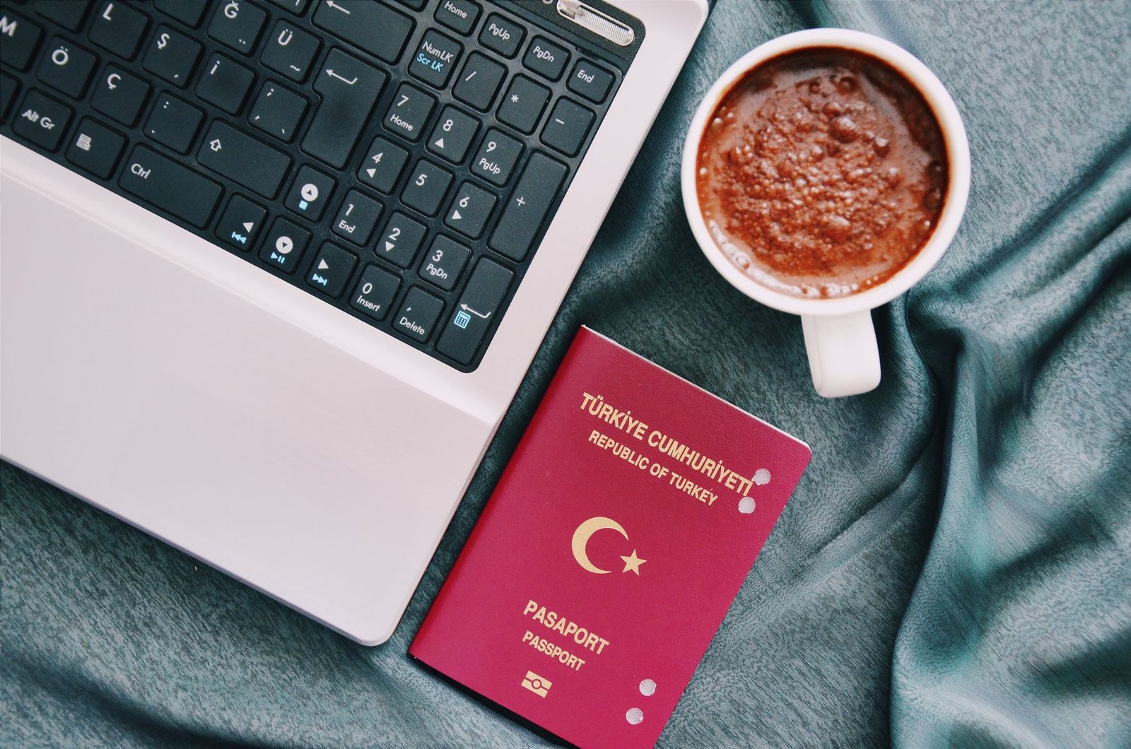 Türk pasaportu dizüstü bilgisayarın yanında; DS-160'ta isim, pasaporttaki Latin harfli yazımla girilir